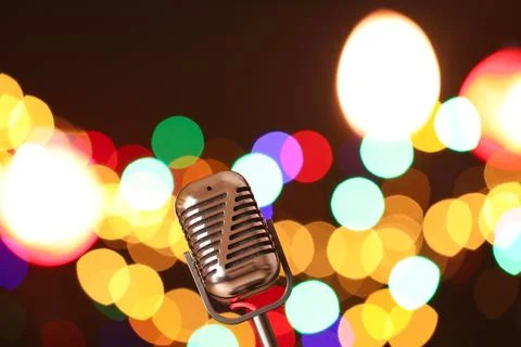 Vintage microphone on dark background with blurred lights, space for text. .. Stock Photos