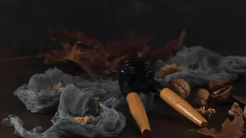 Vintage Nutcracker with Assorted Nuts and Autumn Leaves on a Dark Table Stock Photos