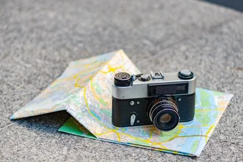 Vintage old camera on a background of old map lying on the stone  - Image Stock Photos