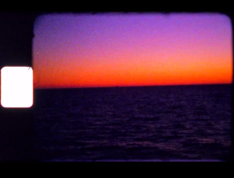Vintage orange and purple sunset view from ship on ocean, filmed on Super 8 film 動画素材 245952553