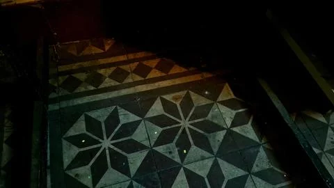 Vintage patterned floor tiles with geometric star shapes and dark shadows Stock Photos