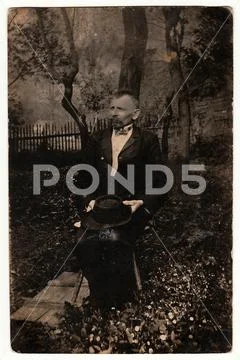 Vintage photo shows elderly man poses outdoors. Black & white photography. Stock Photos