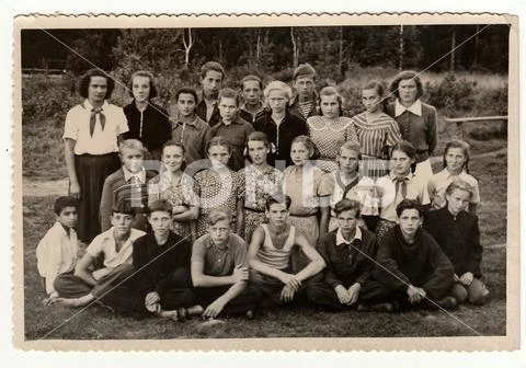 Vintage photo shows teenagers and female chiefs at summer camp. Stock Photos