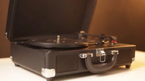 Vintage portable record player opening and playing music with a needle Stock Footage 339003759