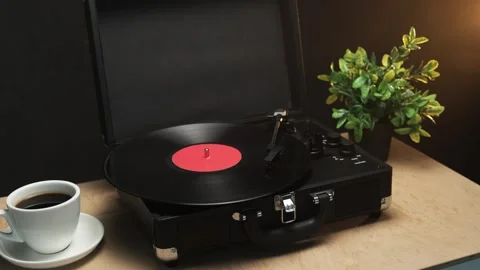 Vintage record player with coffee and plant on wooden table Vidéo 340844685