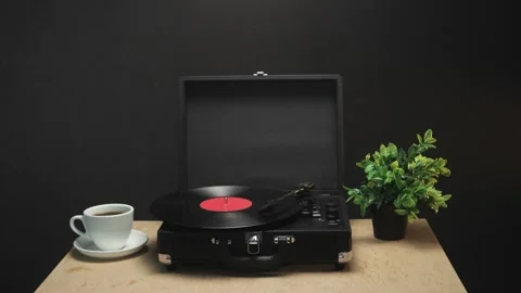 Vintage record player with coffee and plant on wooden table Stockbeeldmateriaal 340844699