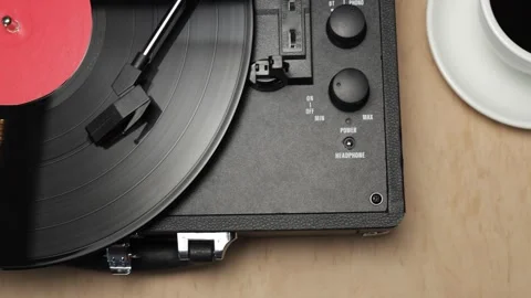 Vintage record player with coffee cup on wooden table Vidéo 340844836