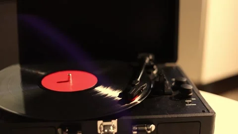Vintage record player spinning a black vinyl disc with a red label Stock Footage 337104703