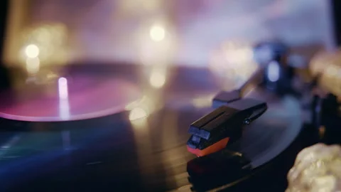 Vintage Record Player Spinning Black Vinyl Disc in Purple and Warm Lighting Stock Footage 345398842