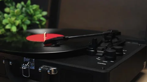 Vintage record player spinning a red vinyl record with a cup of coffee Stockbeeldmateriaal 340844811