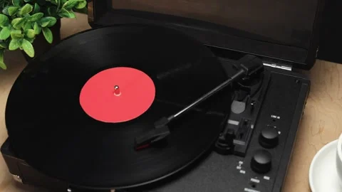 Vintage record player spinning vinyl with a cup of coffee nearby Stockbeeldmateriaal 340844809
