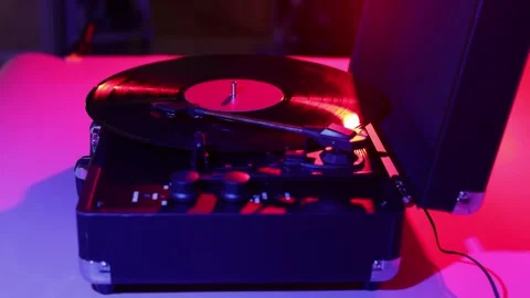 Vintage record player with vinyl spinning under colorful neon lights Stock Footage 339002147