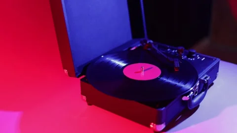 Vintage record player with vinyl spinning under colorful neon lights Stock Footage 339002425