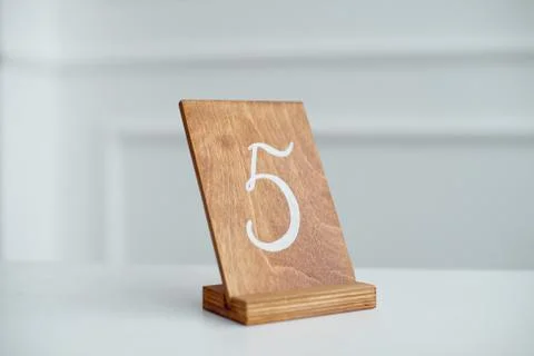 Vintage rectangular shaped wooden number buttons on a white wooden table. Foto stock