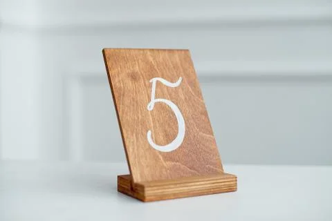 Vintage rectangular shaped wooden number buttons on a white wooden table. Stock Photos