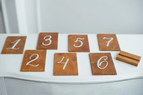 Vintage rectangular shaped wooden number buttons on a white wooden table. Stock Photos