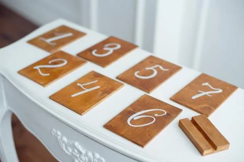 Vintage rectangular shaped wooden number buttons on a white wooden table. Stock Photos