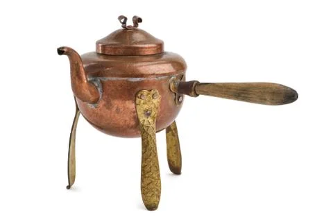 Vintage rustic copper tea kettle with handle and legs isolated on white. Stock Photos