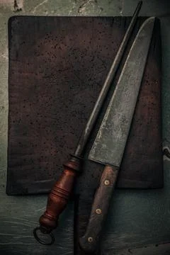 Vintage rustic cutting board with set of kitchen knife and knife sharpener Stock-Fotos