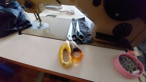 Vintage sewing machine table with scissors, pins and fabric scraps Stock Footage 333642991