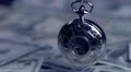 Vintage silver pocket watch hanging above pile of paper money, precious time HD Footage