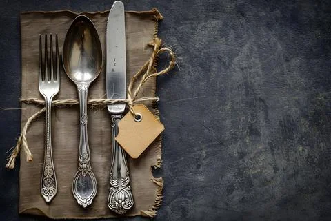 Vintage silverware and label on rustic background Stock Photos