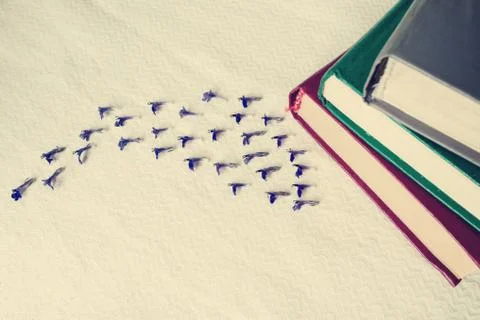 Vintage - stack of books on white tissue and small blue flowers. Stock Photos