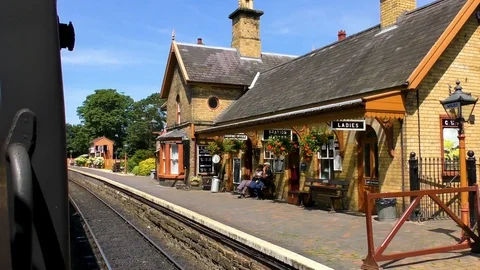 Vintage steam train approaching station platform Stock Footage 80294171