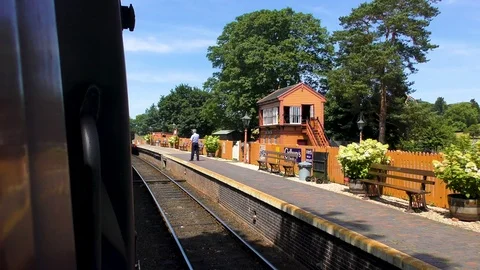 Vintage steam train approaching station platform Stock Footage 80294871