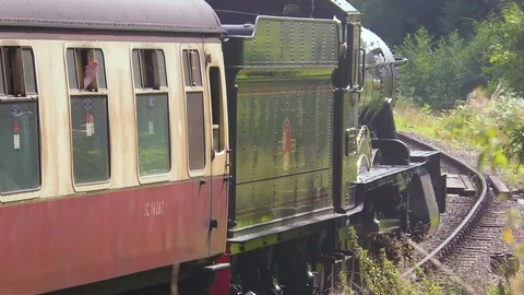 Vintage steam train producing smoke travelling through countryside Stock Footage 80288173