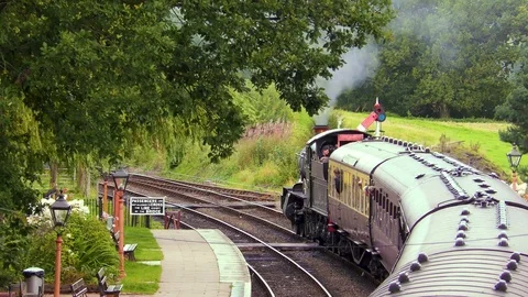 Vintage steam train producing smoke country railway station Stock Footage 80295387