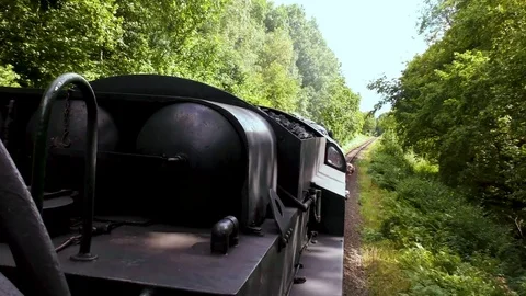 Vintage steam train producing smoke travelling through countryside Stock Footage 80311130