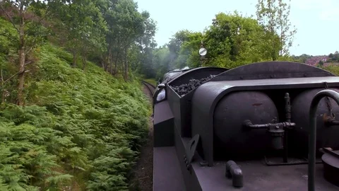 Vintage steam train producing smoke travelling through countryside Stock Footage 80311798