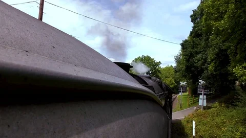 Vintage steam train producing smoke travelling through countryside Stock Footage 80315588