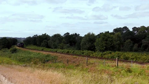 Vintage steam train producing smoke travelling through countryside Stock Footage 80319949