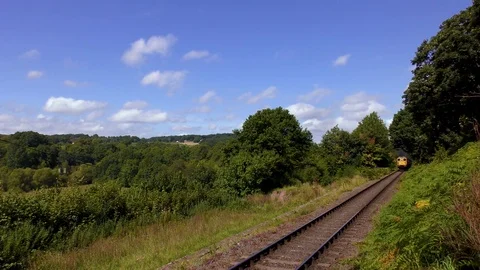 Vintage steam train producing smoke travelling through countryside Stock Footage 80321569