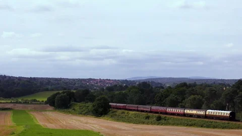 Vintage steam train producing smoke travelling through countryside Stock Footage 80322931