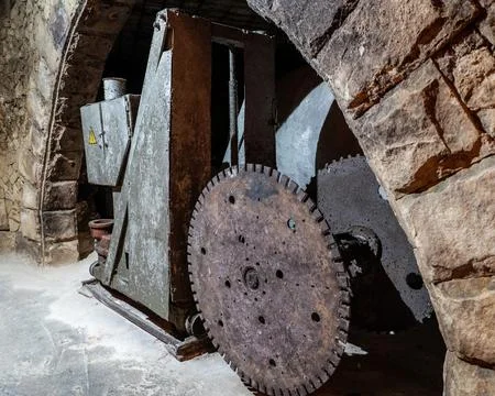 Vintage stone cutting machine inside underground wine cellars tunnel 库存照片