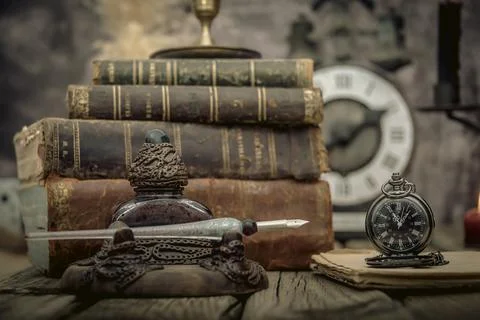 Vintage study table view with books and golden clock in front. Stock Photos