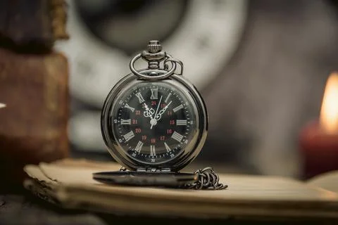 Vintage study table view with books and golden clock in front. Stock Photos