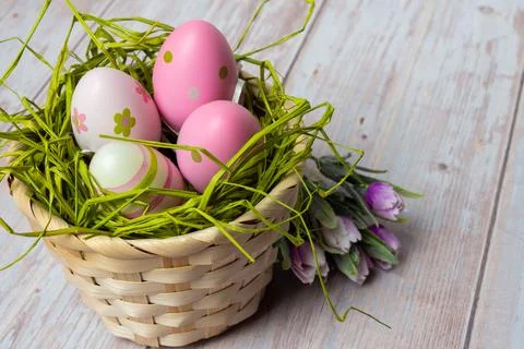 Vintage Style Easter Backdrop With Basket Full Of Colorful Eggs And Tulips Stock Photos
