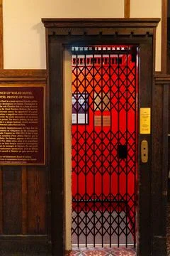 Vintage-style elevator with red gate and classic architecture, inviting ride. Foto stock