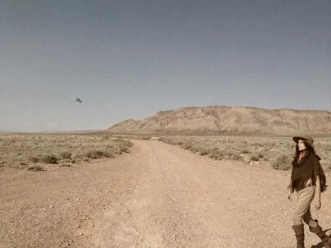 Vintage Style Gun Toting Cowgirl Crossing Arizona Desert Road Stock Video Stock Footage