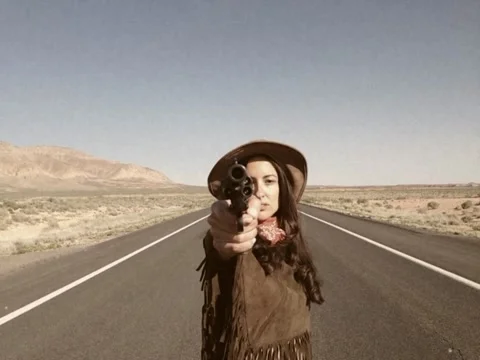 Vintage Style Gun Toting Western Woman Crossing Arizona Desert Road Stock Video Stock Footage