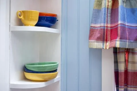 Vintage Style Kitchen Corner with Multi Colored Stoneware and Tartan Drapes Stock Photos