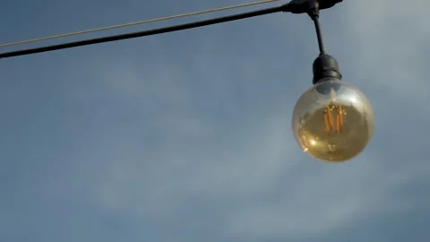 Vintage style LED string lights hanging against a clear blue sky, close-up Video stock 306247255