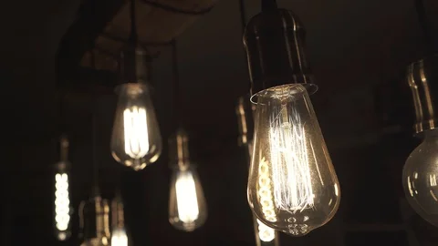Vintage style light bulbs hanging from the ceiling. Old light bulb. Stock Footage 129136009