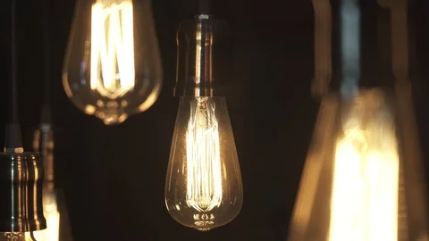 Vintage style light bulbs hanging from the ceiling. Old light bulb. Stock Footage 129136016