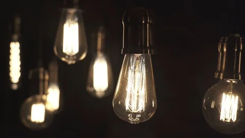 Vintage style light bulbs swinging on the wire in the house. Decorative light Stock Footage 129136129