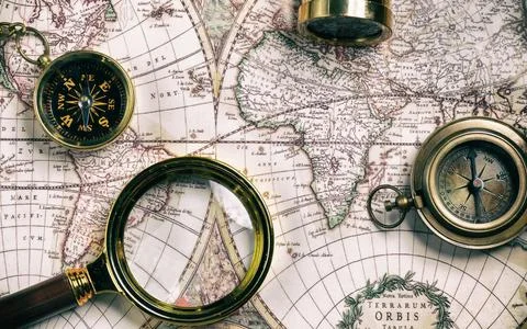 Vintage style navigational objects on an old world map Stock Photos